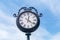 Large exterior clock on clue sky.Â Street vintage retro clock